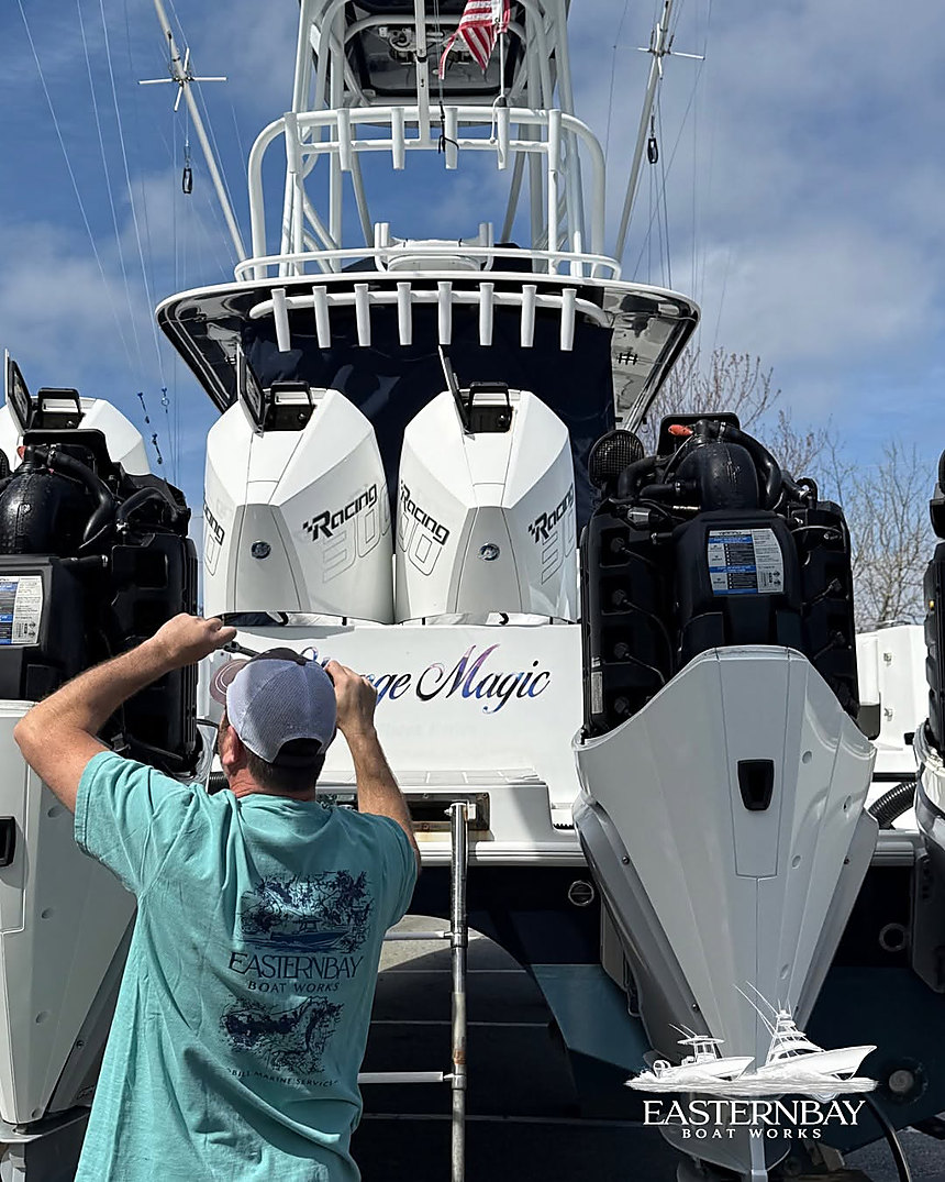 A technician working on the outboards of a sportfishing boat at Eastern Bay Boat Works