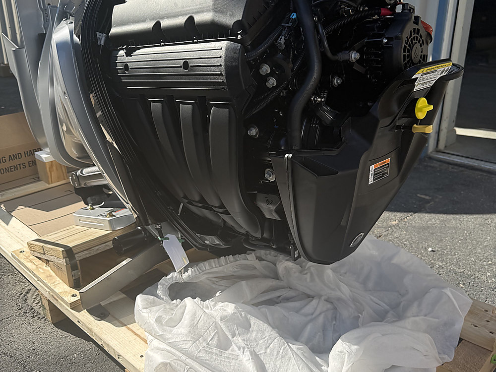 The new Mercury outboard unpacked on a pallet with the cowl removed
